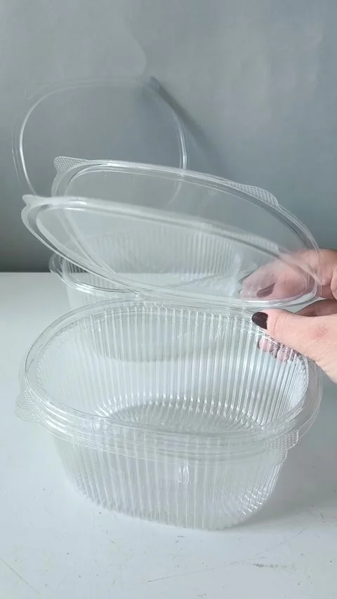 A womans hand touches a plastic disposable transparent food container on the Stock-Footage 330156765