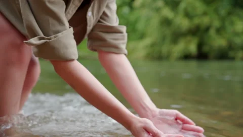 A woman's hand touching the surface of river she feeling relaxed. Stock Footage 252292891
