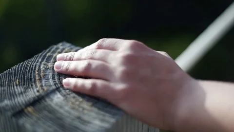 Woman's hand touching a white rope while walking on a wooden walkway. Stock Footage 115079111