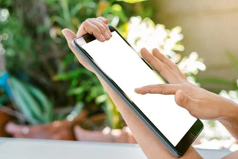 Woman's hand is touching on the white screen of the tablet. Stock Photos