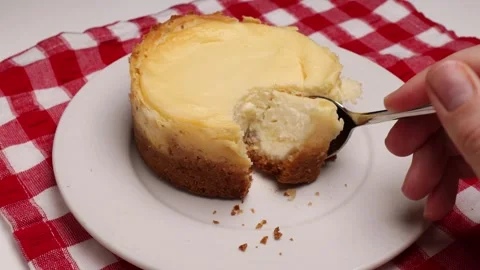 A woman's hand trying a mini homemade cheesecake, gently breaking Stock Footage 280649318