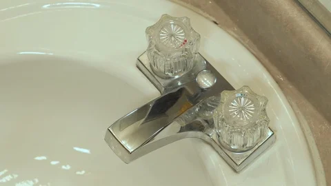 Woman's hand turing on and off bathroom sink Stock Footage 99080655