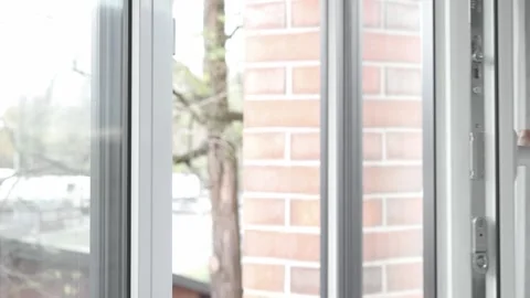 A woman's hand turns the handle of the window frame and opens the plastic window Video stock 255117926