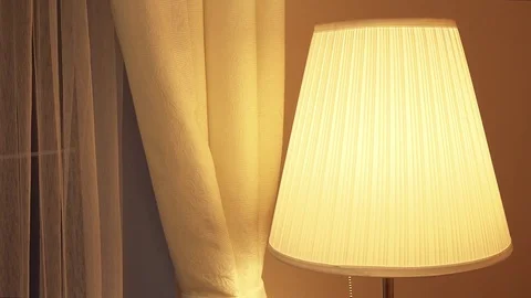 A woman's hand turns on a lamp by a window Vídeo Stock 74671464