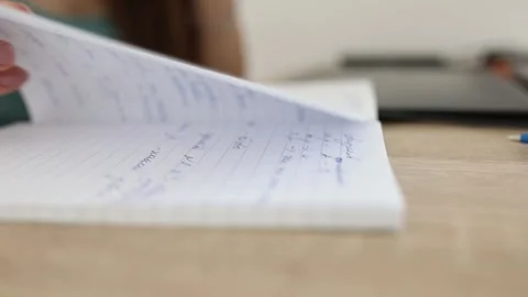 A woman's hand turns over the sheets of a notebook. Stock Footage 244356769