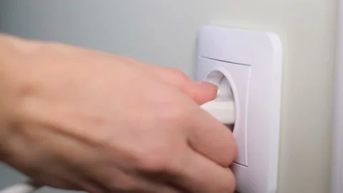 A woman's hand turns off the power from an electrical outlet. Slow motion 動画素材 226246898