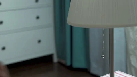 A Woman's Hand Turns On A Table Lamp, Close-up. The Woman Pulls the String and T Stock Footage 158312720
