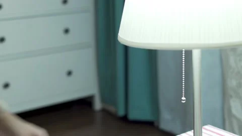 A Woman's Hand Turns Off A Table Lamp, Close-up. The Woman Pulls the String and  Stock Footage 158312799