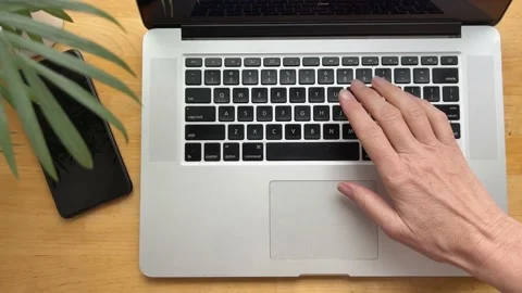 A woman's hand types on a laptop keyboard. Top view Stock Footage 234065726