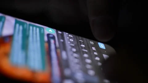 Woman's hand typing on his iphone on a dark background Stock-Footage 201293081