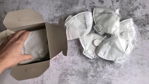 Womans hand unpacking a box full of medical face masks Stock Footage 126787882