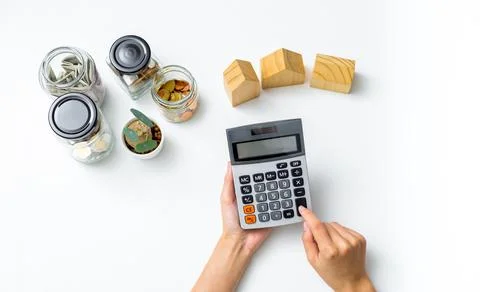Woman's hand using calculator to calculate savings for house on table with mo Foto stock