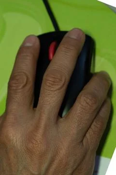 A woman's hand using a computer mouse, working in her office Stock Photos