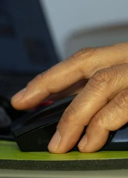 A woman's hand using a computer mouse, working in her office Stock Photos