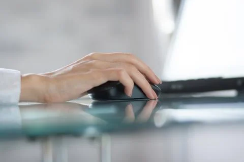 Woman`s hand using cordless mouse in the office Stock Photos