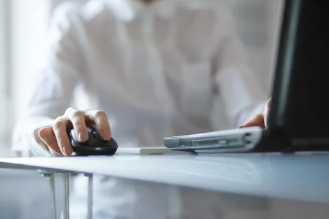 Woman's hand using cordless mouse on glass table Stock Photos