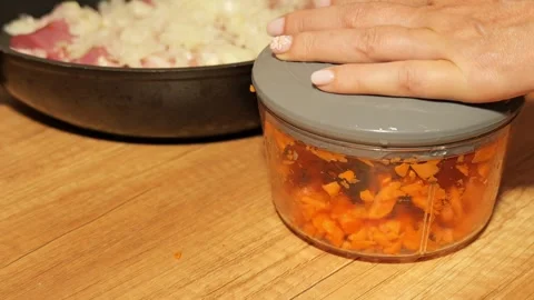 Woman's hand using manual food processor chopping carrots 動画素材 342758684