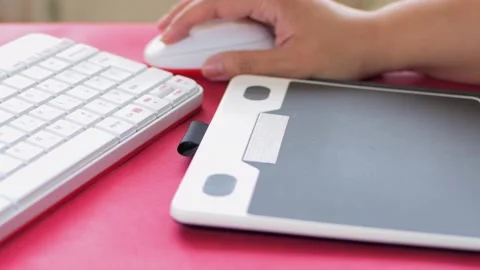 Woman's hand using mouse and graphic tablet to design. On red table. Stock Footage 136135328