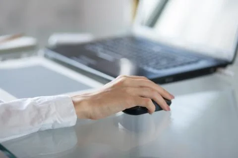 Womans hand using a mouse Stock Photos