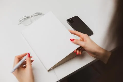 Woman's hand using a pencil noting on notepad at office Stock Photos