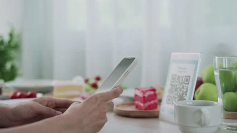 The woman's hand is using the phone to scan the qr code to select the food me Stock Footage 164237095