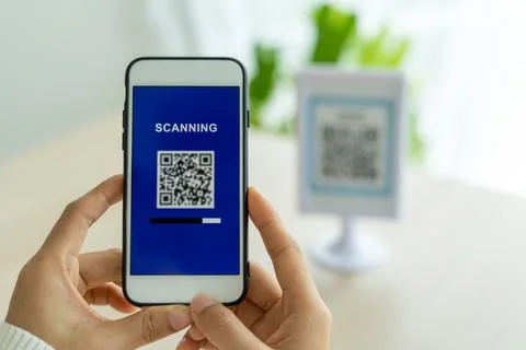 The woman's hand is using the phone to scan the qr code to select the food me Foto stock