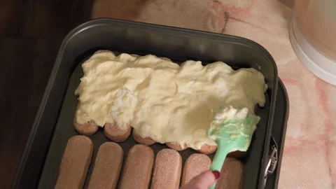 A woman's hand, using a silicone spatula, puts cream on cookies, she prepar.. Video stock 228264831