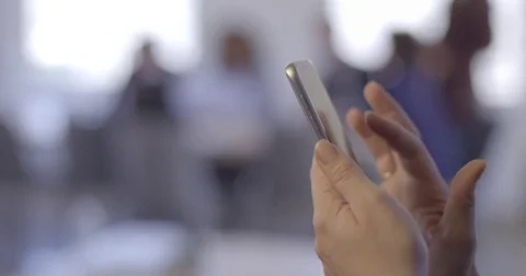 Woman's hand using smart phone in front of soft focus office 4K Stock Footage 79191880