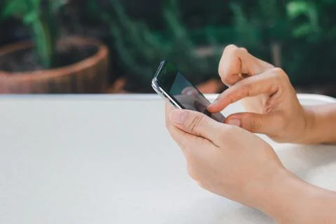 Woman's hand is using a smart phone to search for information online. Stock Photos
