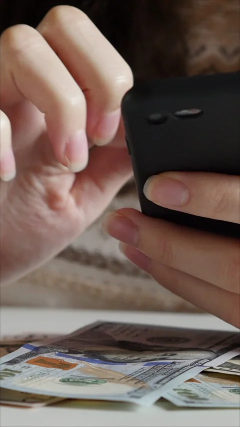 Woman's Hand Using Smartphone On White Desk With Hundred Dollar Bills. Vertical. 스톡 동영상 274909841