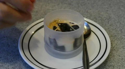 Woman's hand using spoon to eat coffee jelly dessert Stock Footage