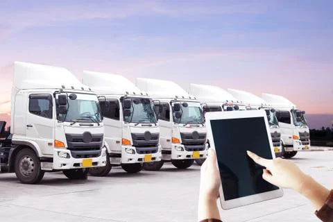 Woman's hand is using tablet with logistics transportation new truck fleet Stock Photos