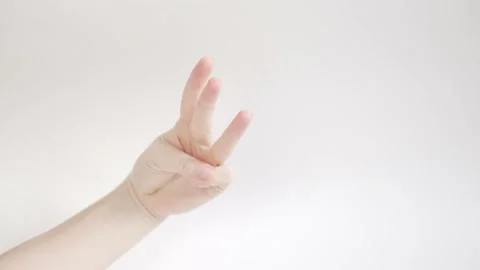 A woman's hand on a white background shows three and four fingers and claps her Stock Footage 162797134