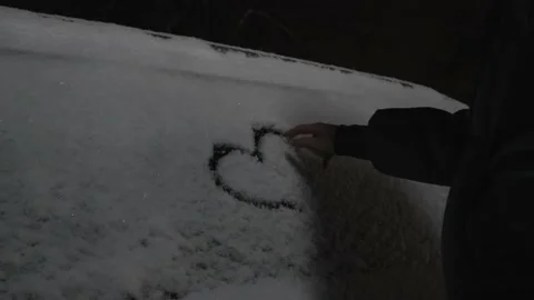 Woman's hand on winter day draws heart with her hands on side window of car. Stock Footage 229970149