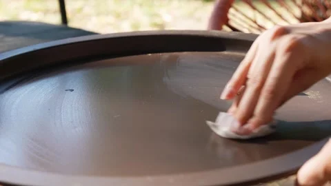 A woman's hand wipes the coffee table clean of dirt. Stock Footage 280081625
