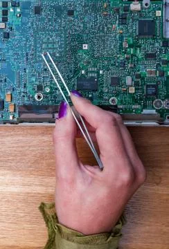 Woman's hand  working on computer circuit board components Stock Photos