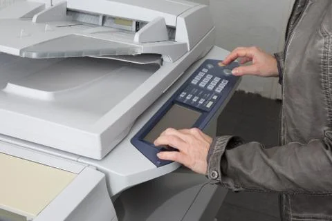 Womans hand with a working copier at work Stock Photos