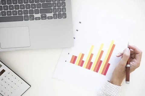Woman's hand working with a laptop computer analyzing a graph. Foto stock