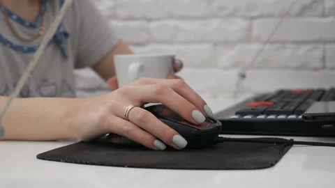 The woman's hand is working with the mouse on the table and.Remote work Stock Footage 131874371