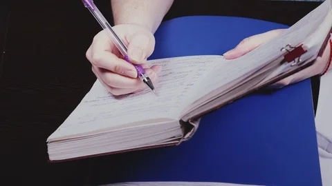 A woman's hand writes numbers in a notebook Stock Footage 103164625