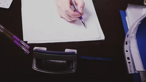 A woman's hand writes numbers on a piece of paper Stock Footage 103164079