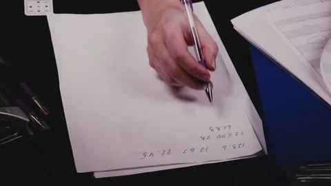 A woman's hand writes numbers on a piece of paper Stock Footage 103164420
