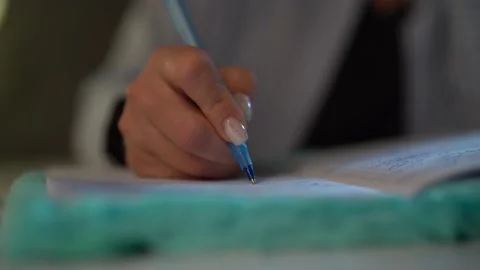 A woman's hand writes with a pen in a notebook. close-up Video stock 153464995
