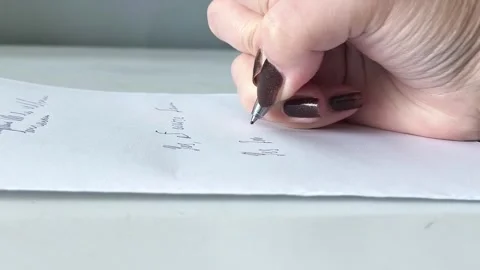 A womans hand writes with a pen on a piece of paper in close-up. Exams, tests at 库存影片 330156735