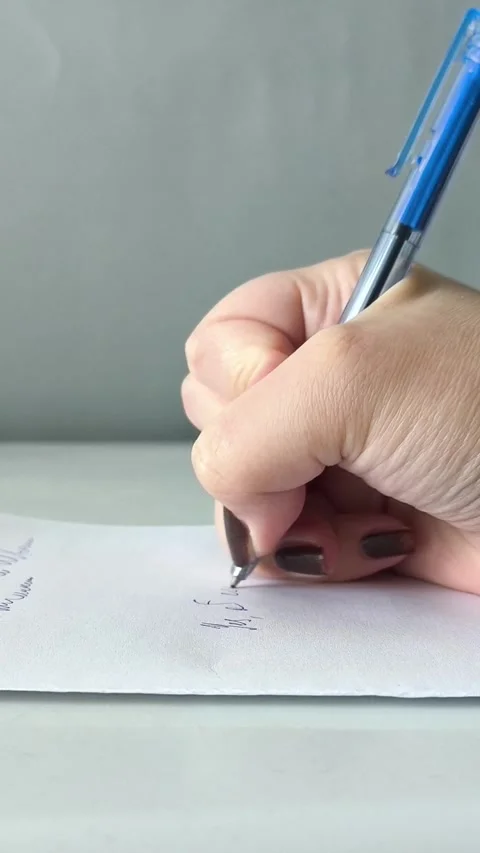 A womans hand writes with a pen on a piece of paper in close-up. Exams, tests at 库存影片 330156741
