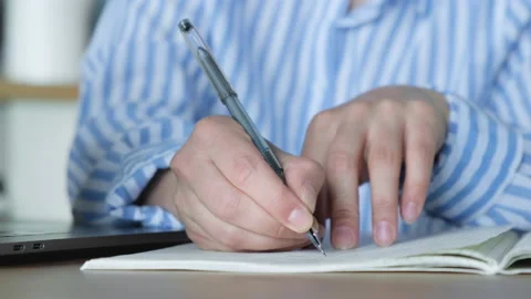 A Woman's Hand Writes Tasks In A Notebook Sitting At The Table Stock Footage 134440308