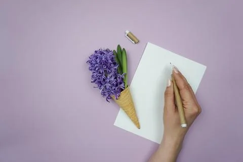 A woman's hand writes on a white sheet of paper. Stock Photos