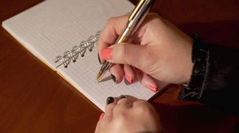 Woman's hand writes word HELLO on the notebook Stock Footage 62089077