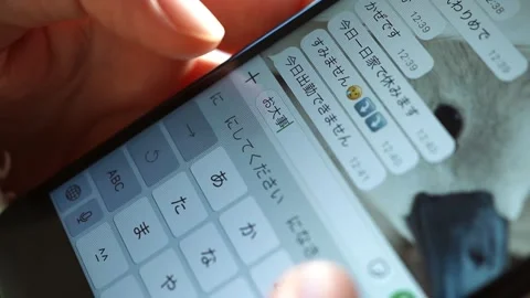 Woman's hand writing a message  “Take care ” in Japanese on her cellphone Stock Footage 298989659