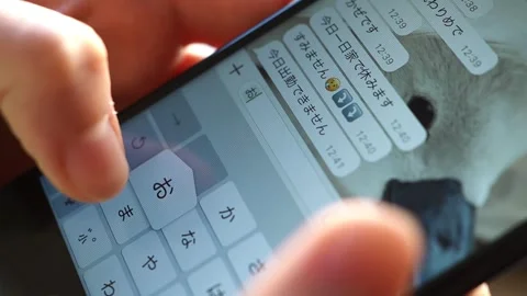 Woman's hand writing a message  “Take care ” in Japanese on her cellphone Stock Footage 298989662